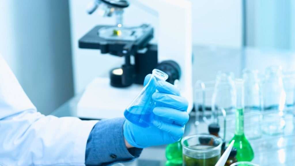 Scientist holding blue liquid in laboratory flask